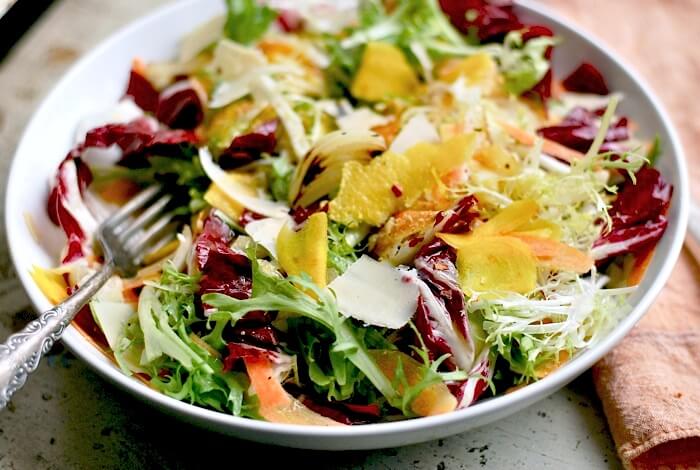 Seared cippolini onions lend depth to this jewel-toned radicchio and frisee salad with shaved beets and carrots.