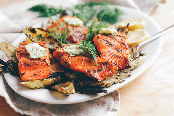 A platter of grilled salmon, fennel, and corn.
