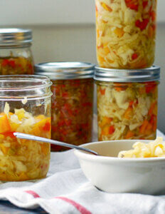 Some jars of chowchow and a little bowl filled with a bit of chowchow.