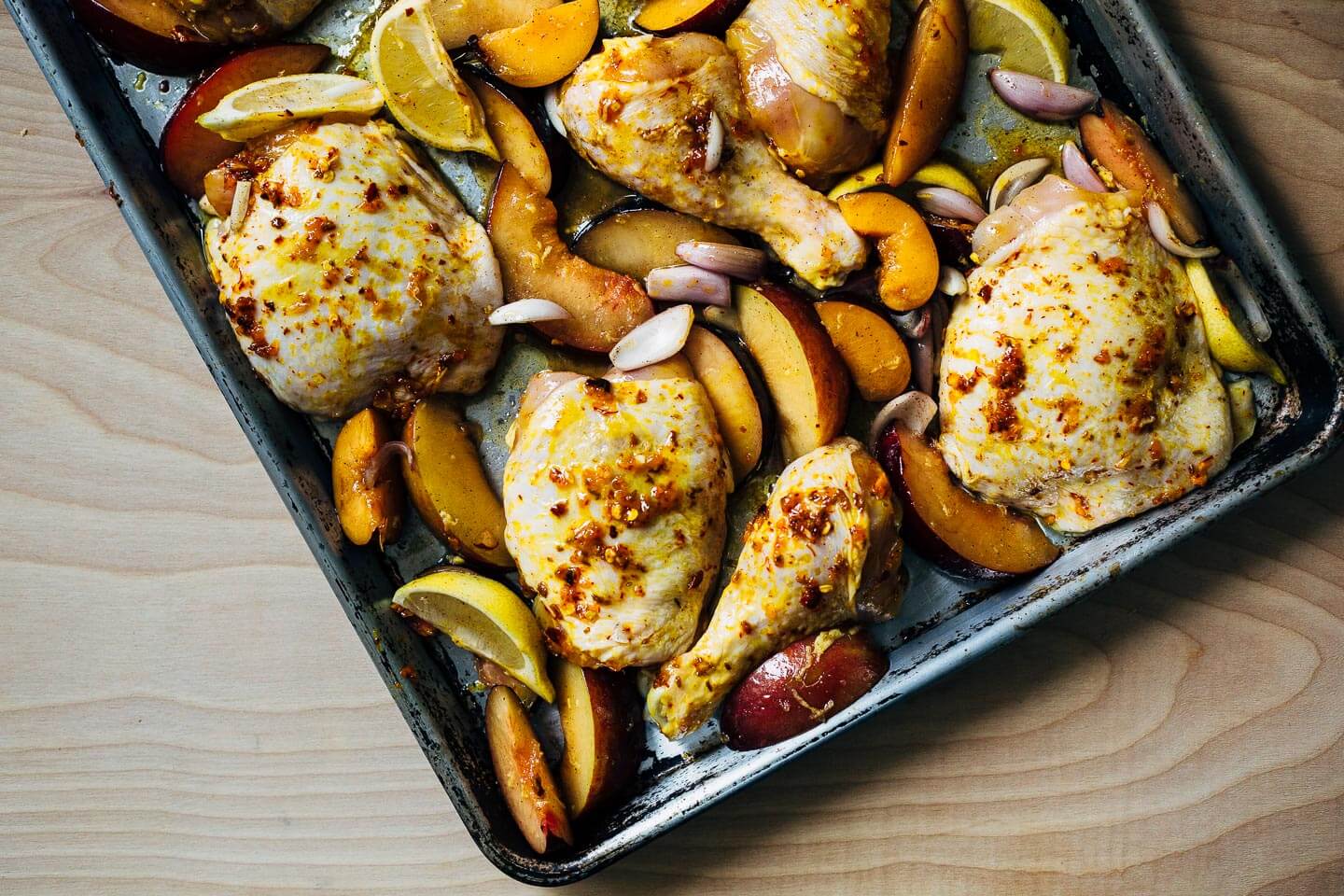A simple sheet pan chicken and plums recipe featuring crispy saffron- and garlic-infused chicken topped with a sweet and savory plum pan sauce.