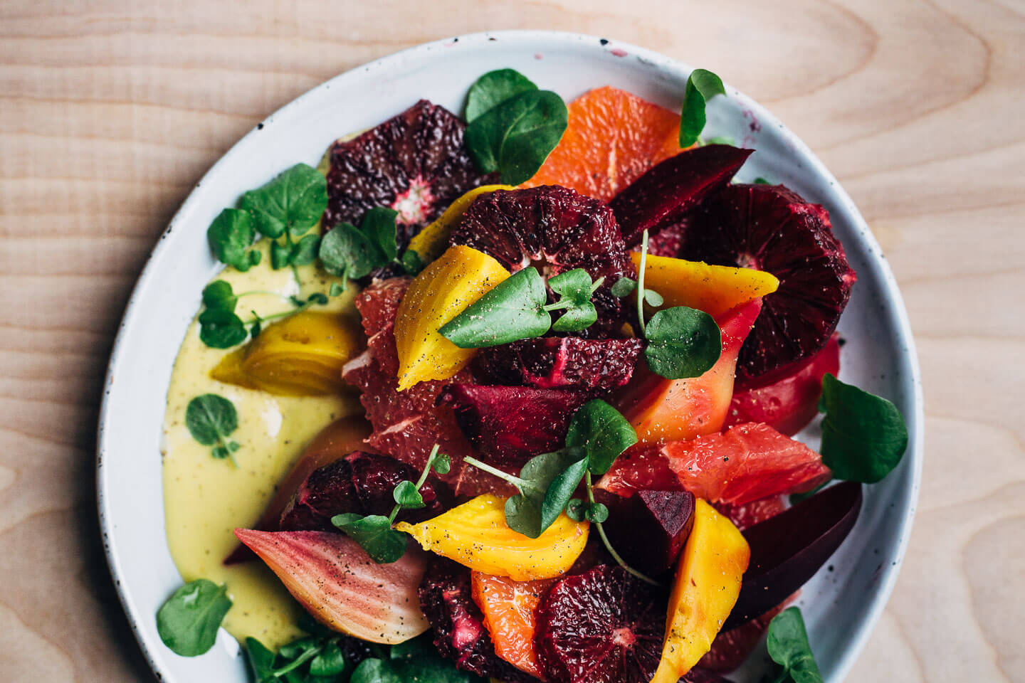 A jewel-toned winter orange and beet salad with layers of Cara Cara and blood oranges, grapefruit segments, red, yellow and chioggia beets, and a creamy homemade grapefruit aioli. 