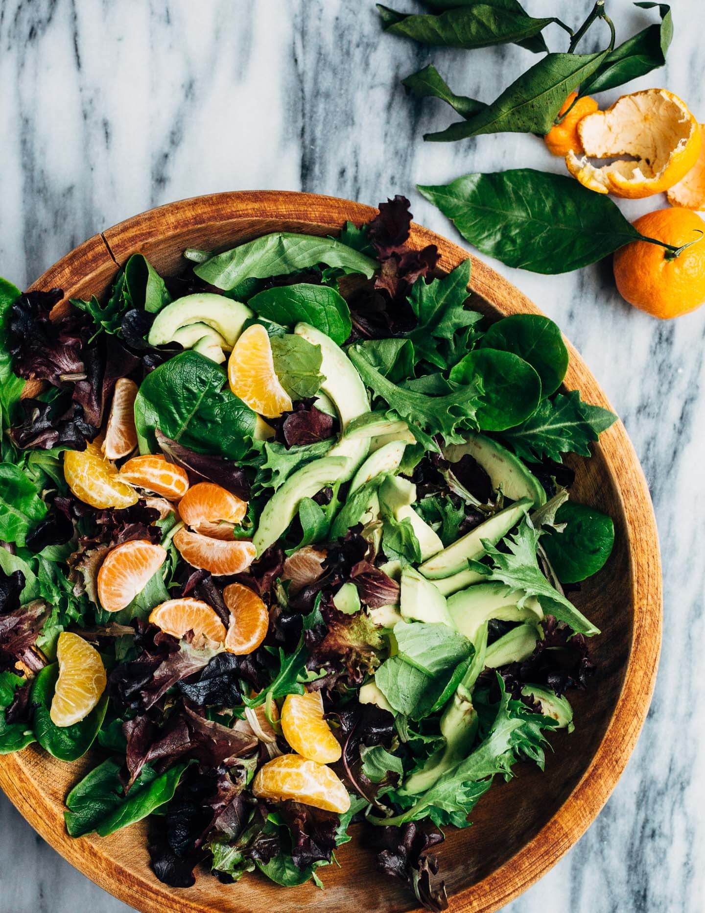 A healthful, Whole30-compliant avocado and mandarin orange salad topped with crisp sesame-crusted baked chicken tenders and drizzled with a creamy mandarin-ginger dressing.