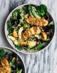 A healthful, Whole30-compliant avocado and mandarin orange salad topped with crisp sesame-crusted baked chicken tenders and drizzled with a creamy mandarin-ginger dressing.