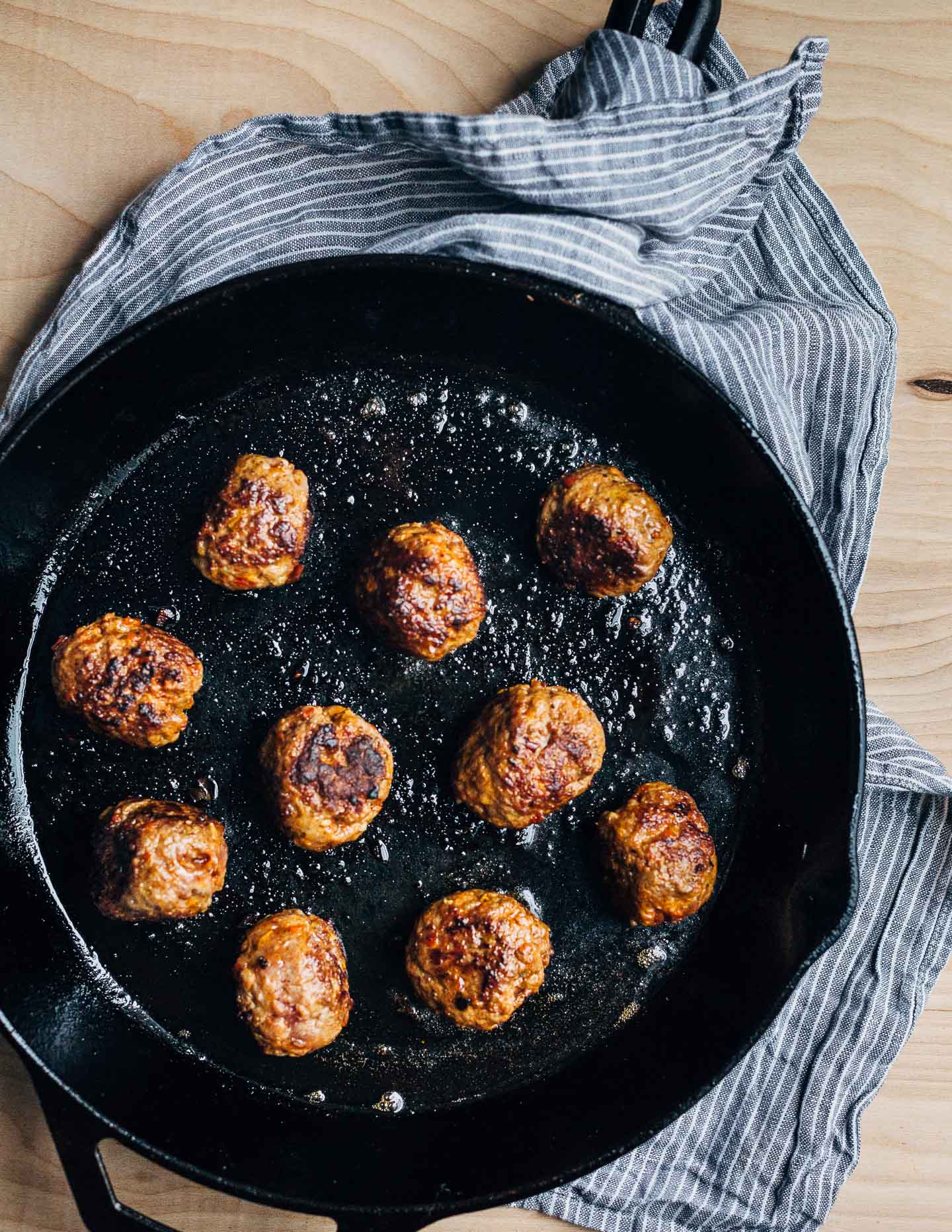 Exceptionally delicious merguez meatball flatbreads layered with red cabbage slaw, herbed yogurt, and harissa. 