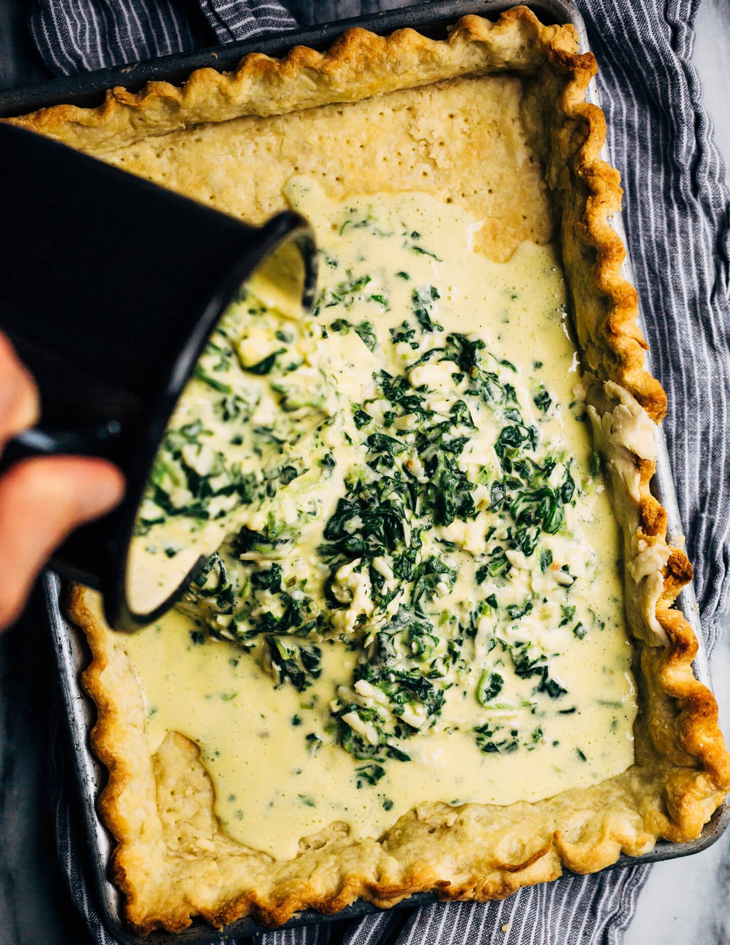 Ideal for Mother's Day brunch or spring gatherings, this sheet pan spinach quiche, made with ramps, green garlic, and chives, is a delicious way to feed a crowd.