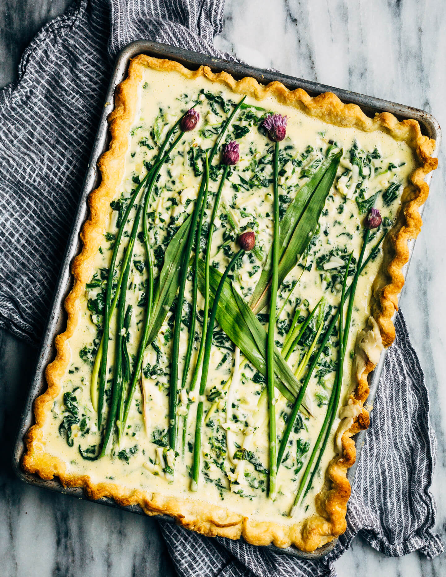 Ideal for Mother's Day brunch or spring gatherings, this sheet pan spinach quiche, made with ramps, green garlic, and chives, is a delicious way to feed a crowd.