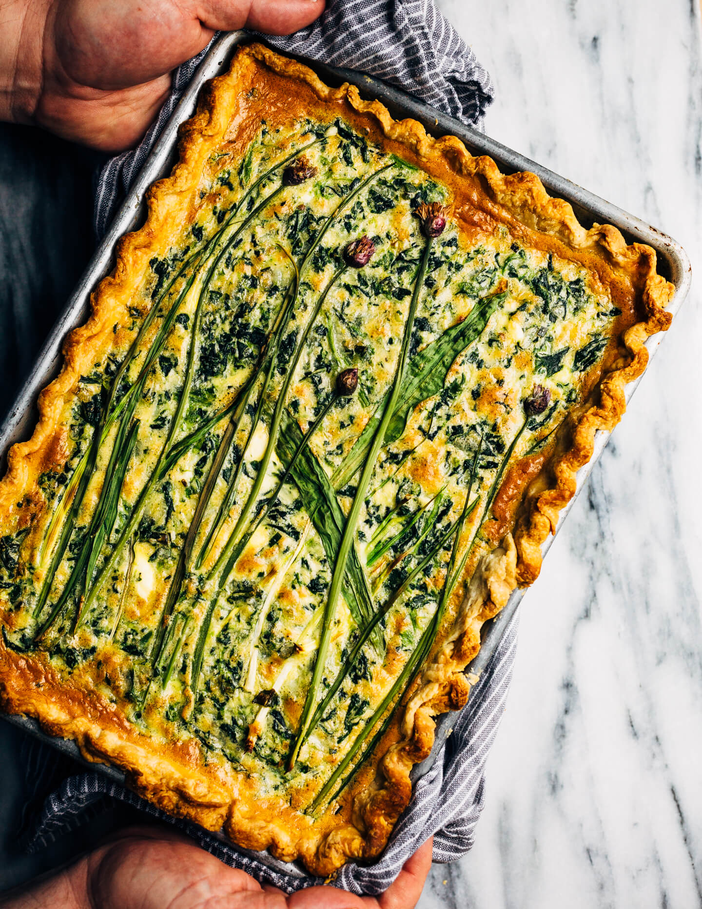 Ideal for Mother's Day brunch or spring gatherings, this sheet pan spinach quiche, made with ramps, green garlic, and chives, is a delicious way to feed a crowd.