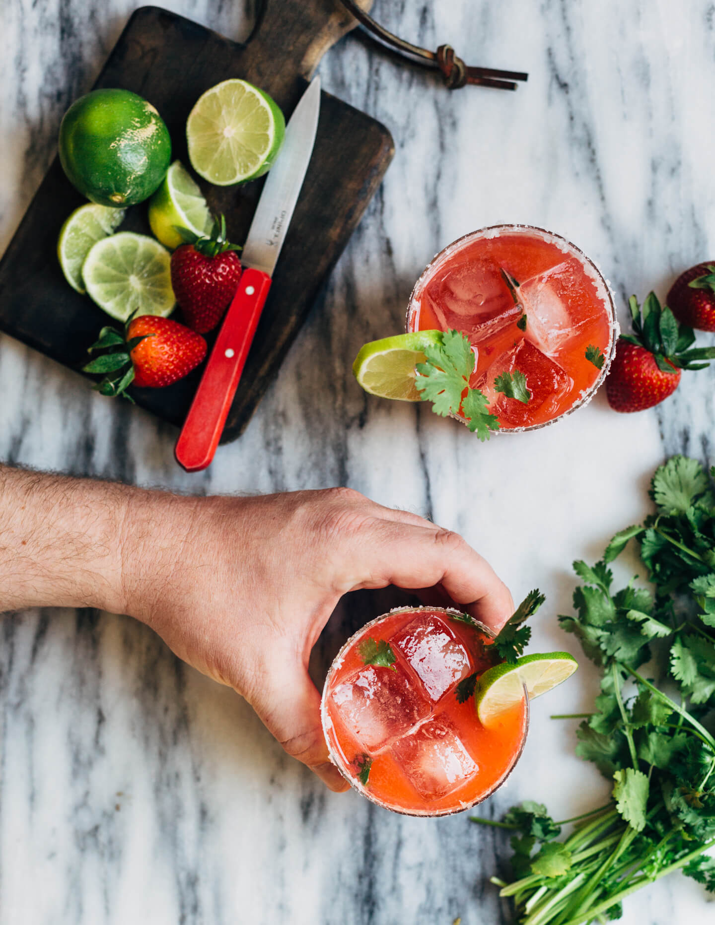 Pretty pink strawberry margaritas blended with an herbaceous cilantro, coriander, and black pepper simple syrup. These fresh strawberry margaritas are beautifully balanced and totally refreshing. 