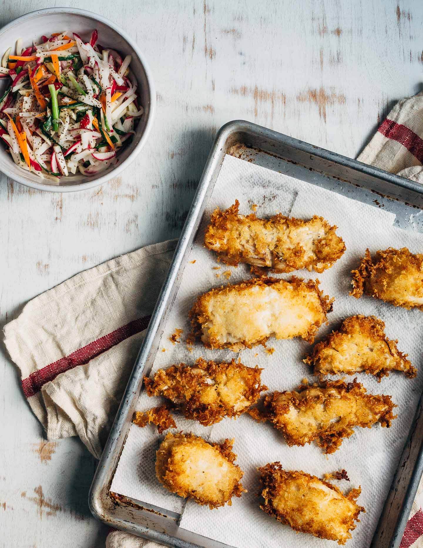 Panko-crusted fried fish sandwiches that are just right for a weeknight at home or a crowd-pleasing feast. Served with a simple radish slaw and bread and butter pickles, these flaky fish sandwiches hit all the right notes.