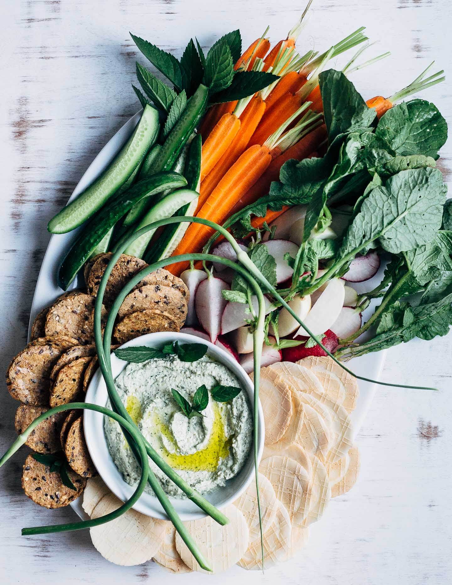 This lemony labneh and garlic scape dip is a wonderfully simple appetizer for warm weather fêtes. Creamy labneh, blended with sautéed garlic scapes, fresh mint leaves, and lemon zest, makes for a vibrant, crowd-pleasing dip.