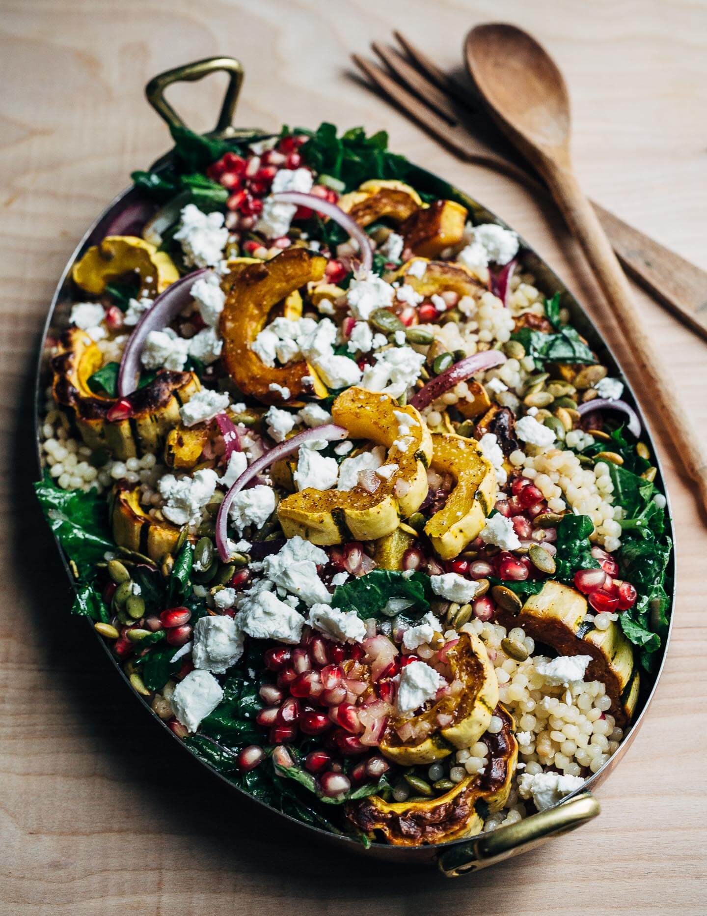 A vibrant, yet sturdy, pearl couscous and roasted delicata squash salad, tossed with tender kale, pomegranate arils, pepitas, and crumbled goat cheese, that's perfect as autumnal side dish or a versatile meal prep lunch. 