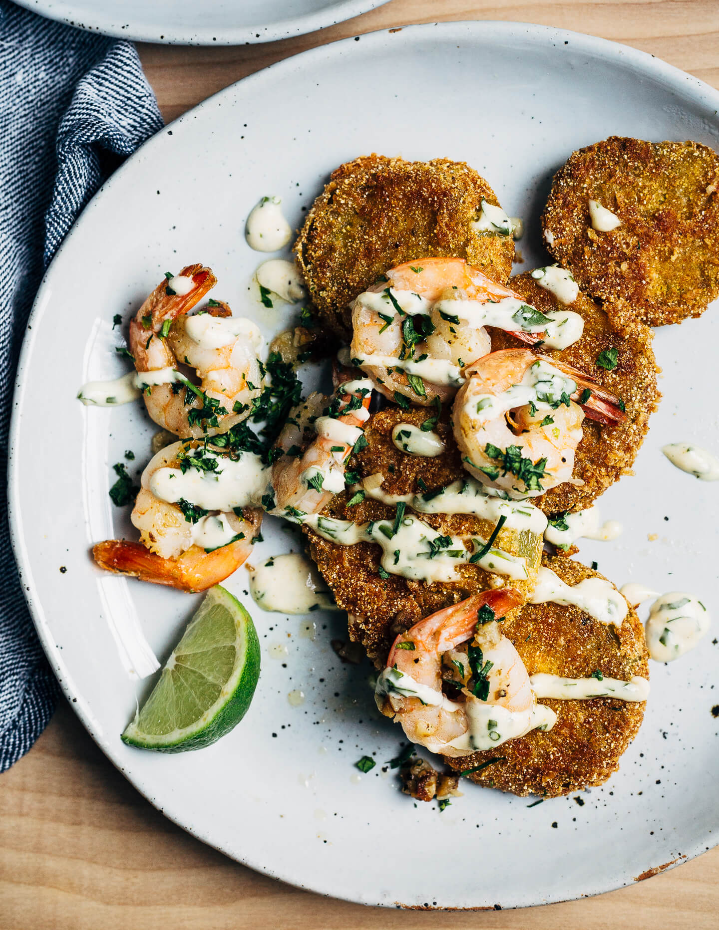 Putting leftover green tomatoes to good use with a recipe for crisp, savory fried green tomatoes topped with garlicky sautéed shrimp and a super simple remoulade.