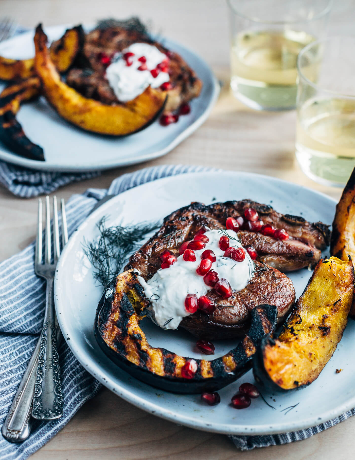 Add a pop of char and smoke to your Thanksgiving feast with this recipe for cumin-rubbed grilled lamb chops, grilled acorn squash wedges, dill and fennel tzatziki, and pomegranate arils. 