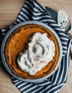 Looking down on a sweet potato pie with whipped cream on top.