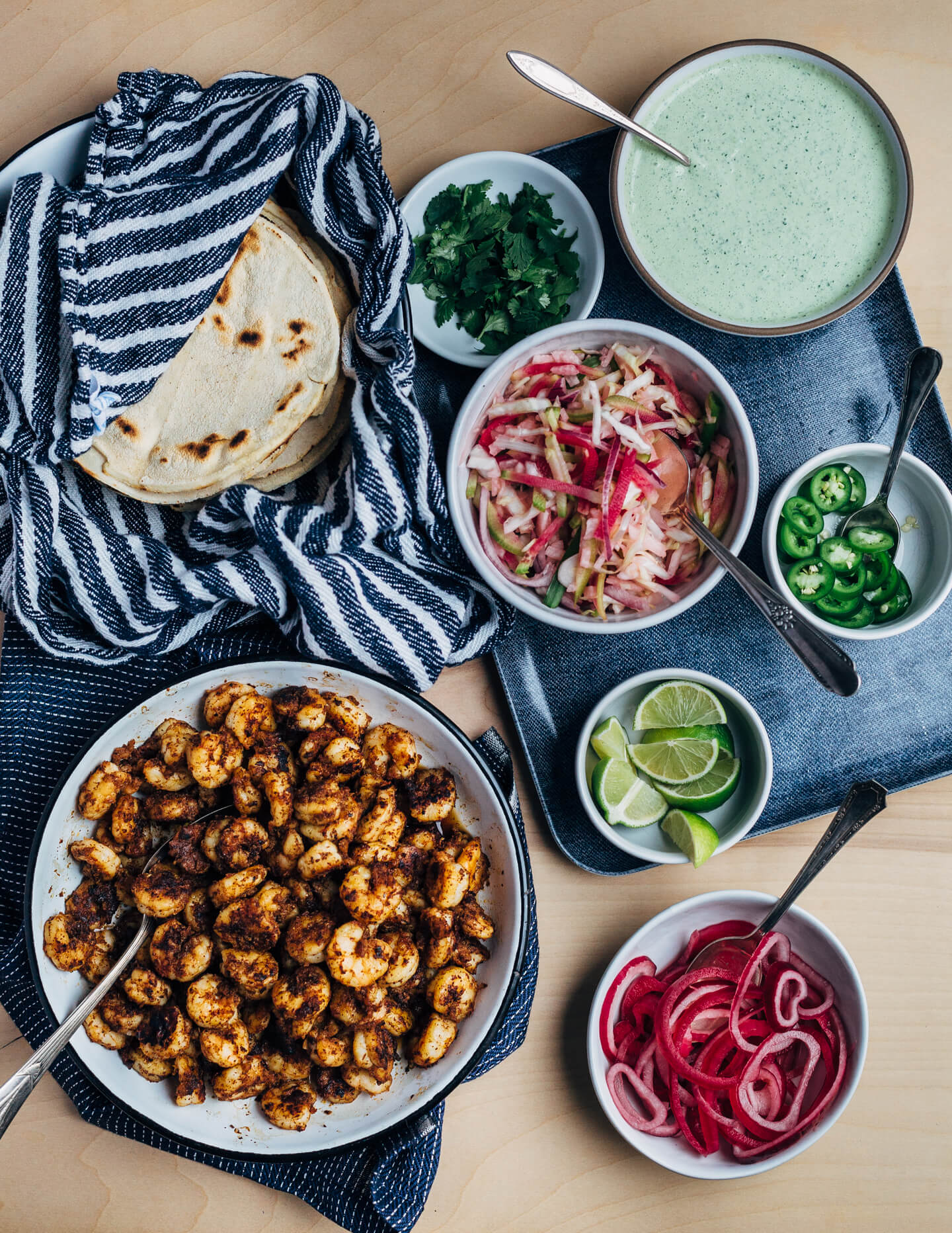 These easy (and delicious!) shrimp tacos feature pan-seared shrimp tossed with lots of chili, cumin, and garlic powder, a simple winter slaw made with watermelon radishes and jicama, and a quick cilantro-yogurt blender sauce. 