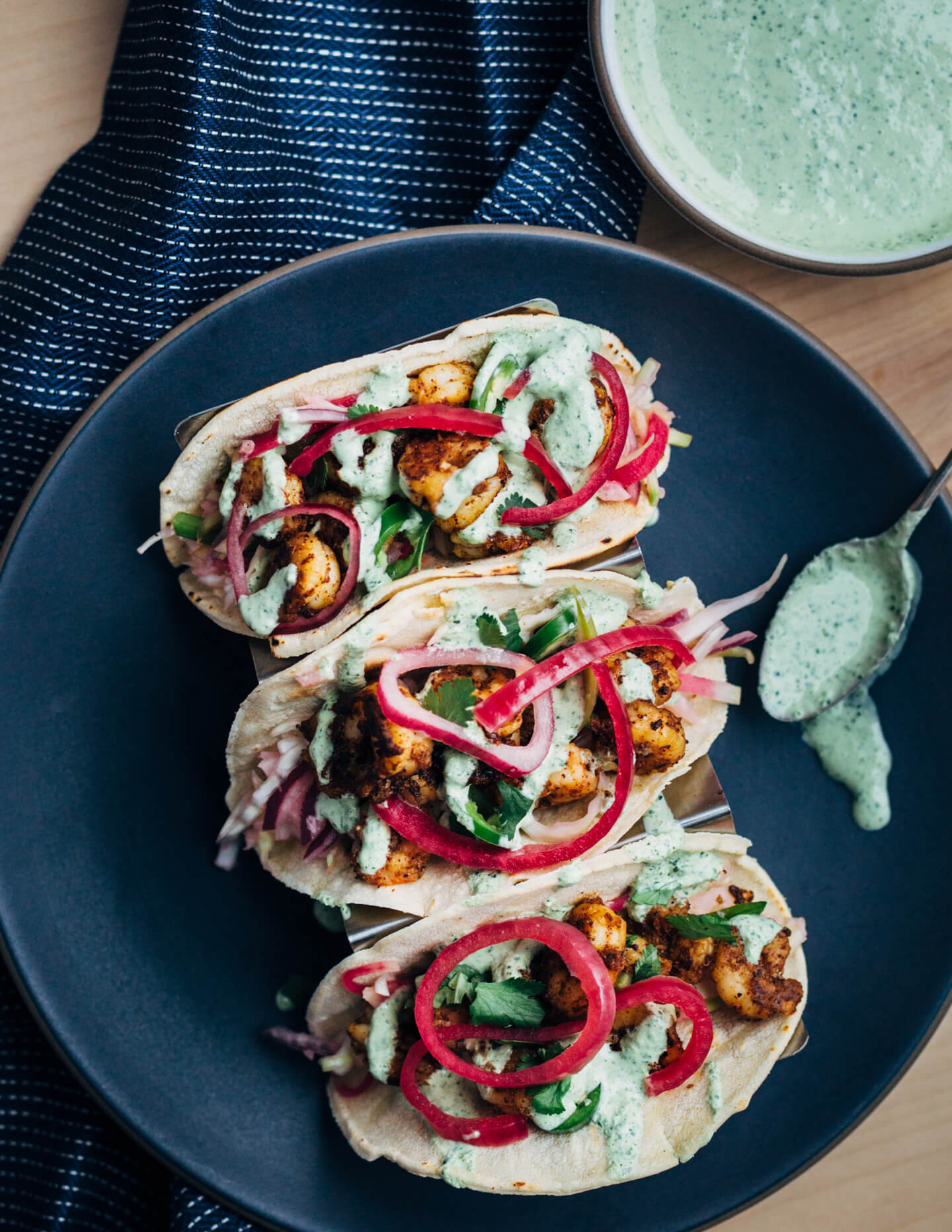 These easy (and delicious!) shrimp tacos feature pan-seared shrimp tossed with lots of chili, cumin, and garlic powder, a simple winter slaw made with watermelon radishes and jicama, and a quick cilantro-yogurt blender sauce. 