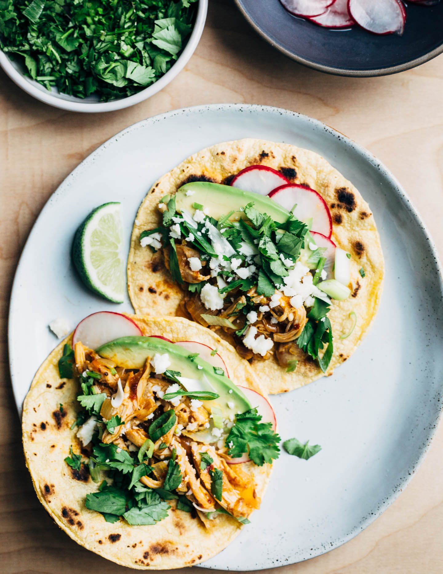 Chipotle chilies in adobo sauce lend smoky heat to these classic chicken tacos topped with avocado, radish, cilantro, and crumbled cotija. This post was created in partnership with SVO Farmer Focus Chicken. 