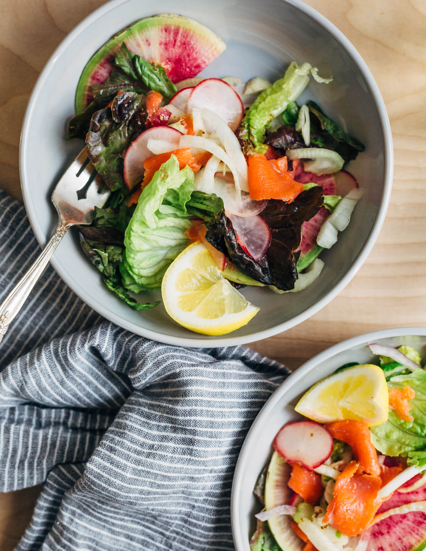 A colorful smoked salmon salad to herald spring! Smoked salmon and delicate lettuces are layered with thinly sliced fennel, radish, and red onion, and tossed with an assertive Dijon and horseradish vinaigrette. 