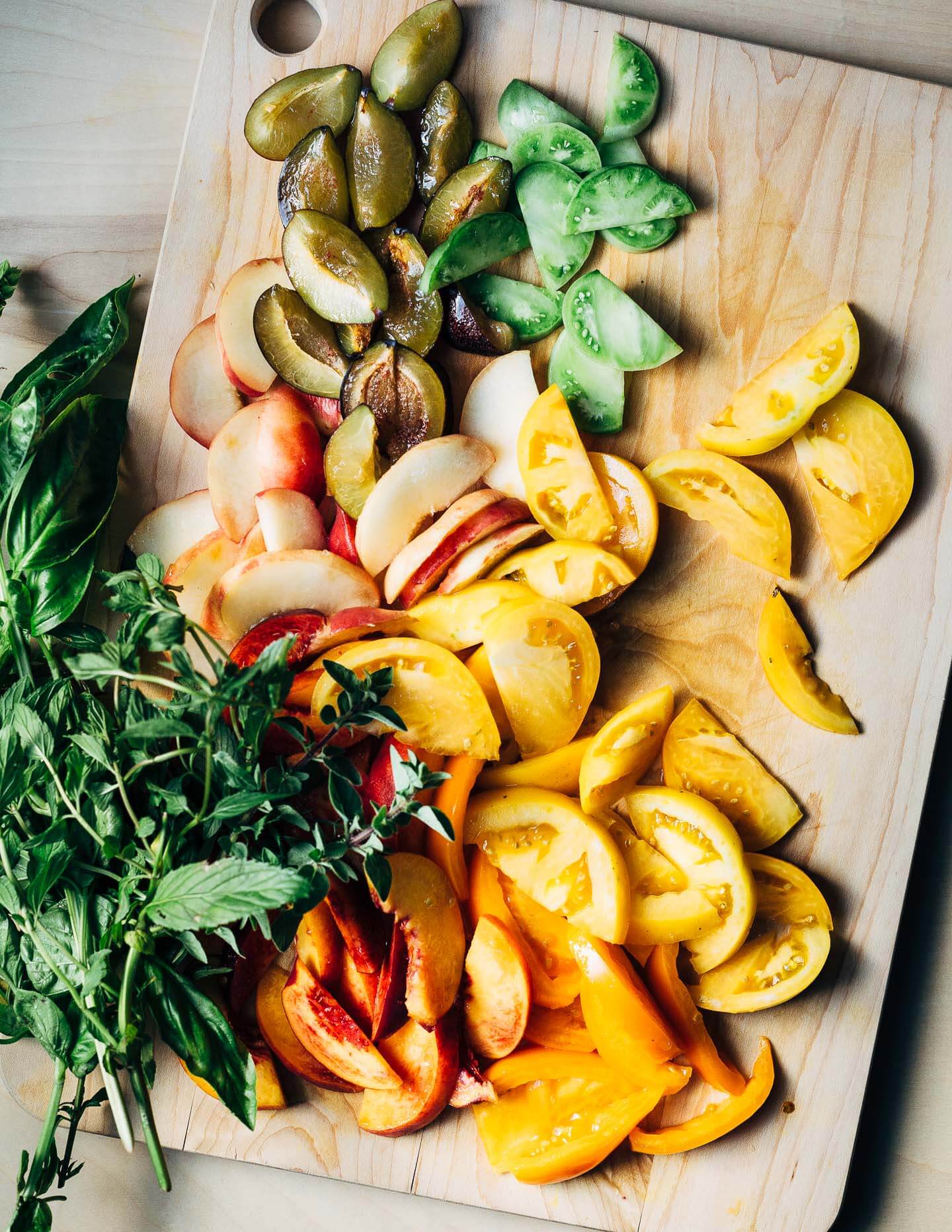 Sliced tomatoes, peaches, and plums