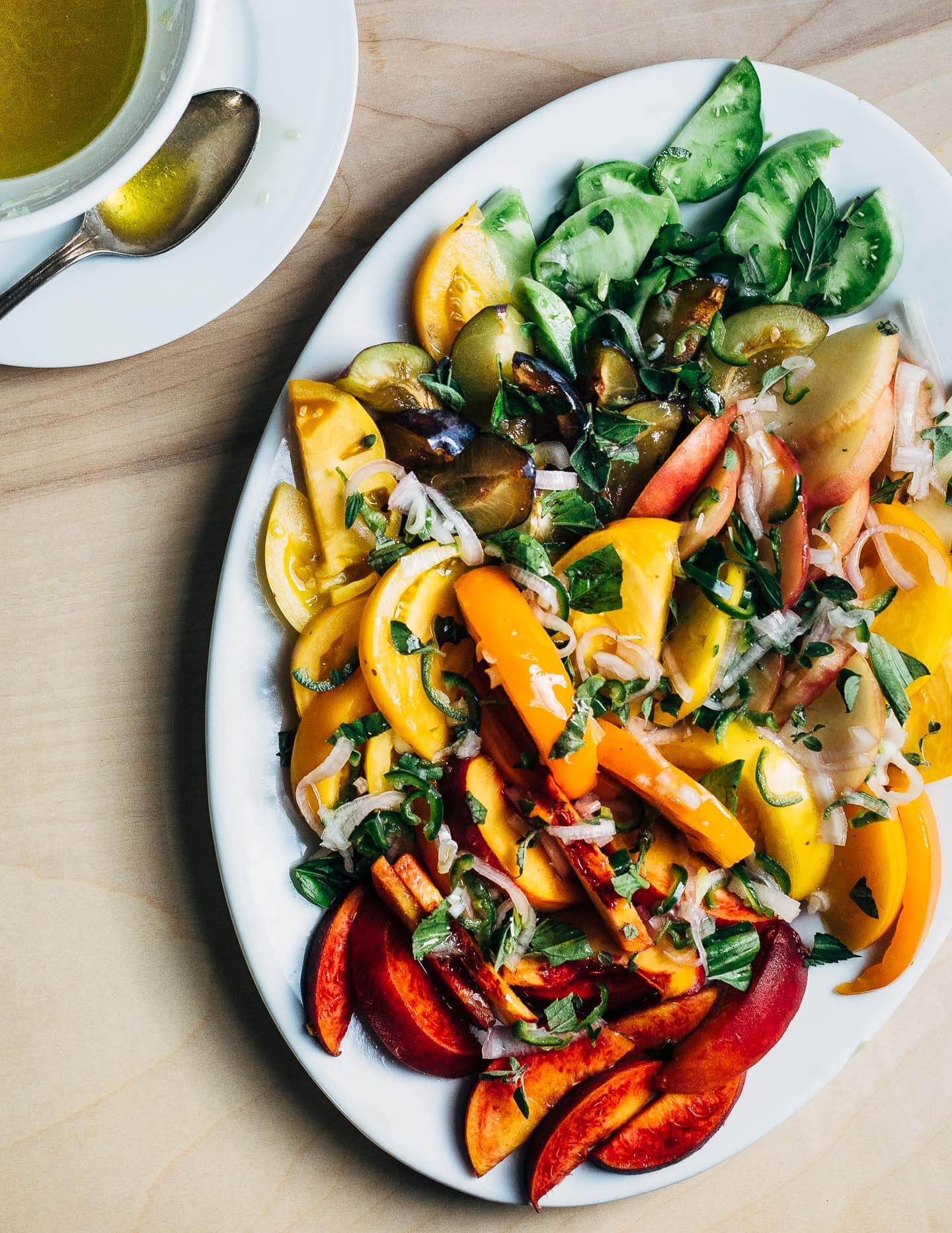 A simple stone fruit and tomato salad with Serrano-lime dressing, burrata, and fresh herbs.