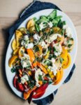 Peak summer ingredients speak for themselves in this layered stone fruit and tomato salad tossed with torn burrata, fresh garden herbs, and a spicy Serrano-lime dressing.