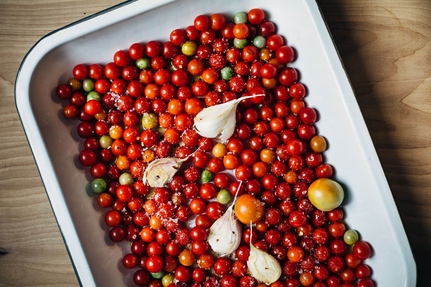 Cherry tomatoes, garlic, and olive oil, ready to be roasted up for a quick fresh tomato marinara.