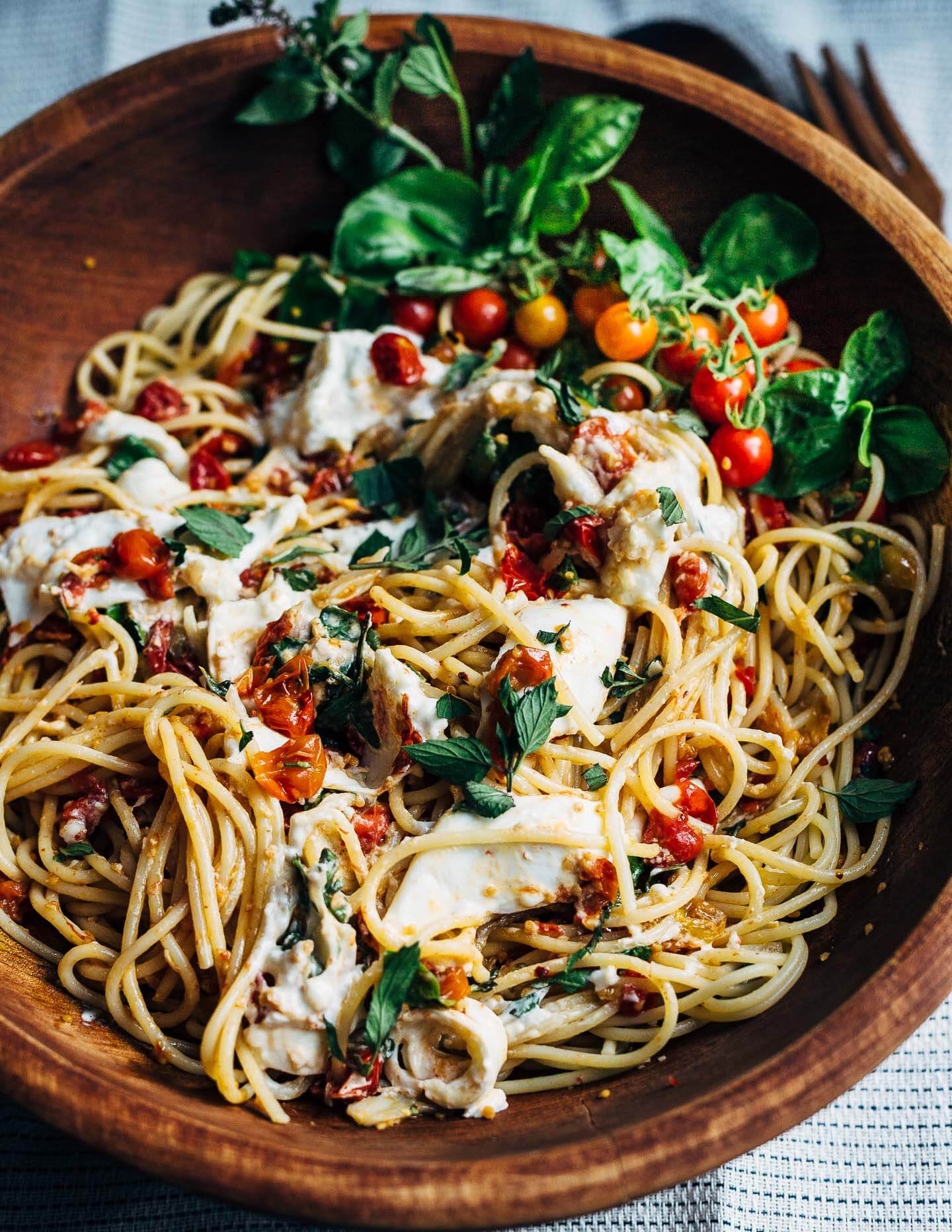 A simple, slightly spicy roasted cherry tomato marinara served over al dente spaghetti and topped with burrata and fresh herbs.