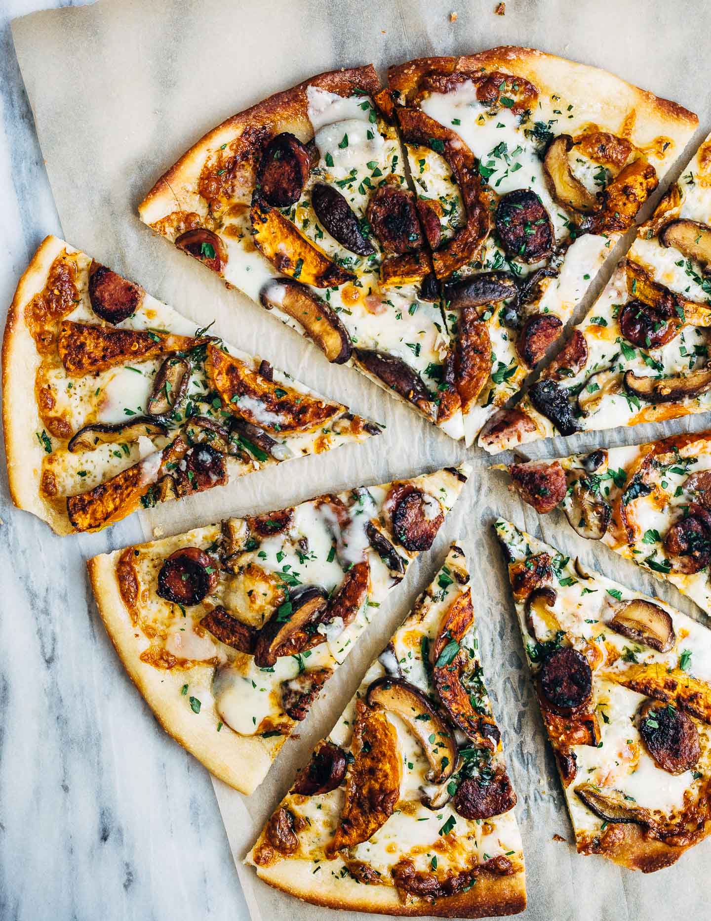 A savory, fall-inspired roasted butternut squash and sausage pizza with garlicky sautéed mushrooms and fresh herbs.