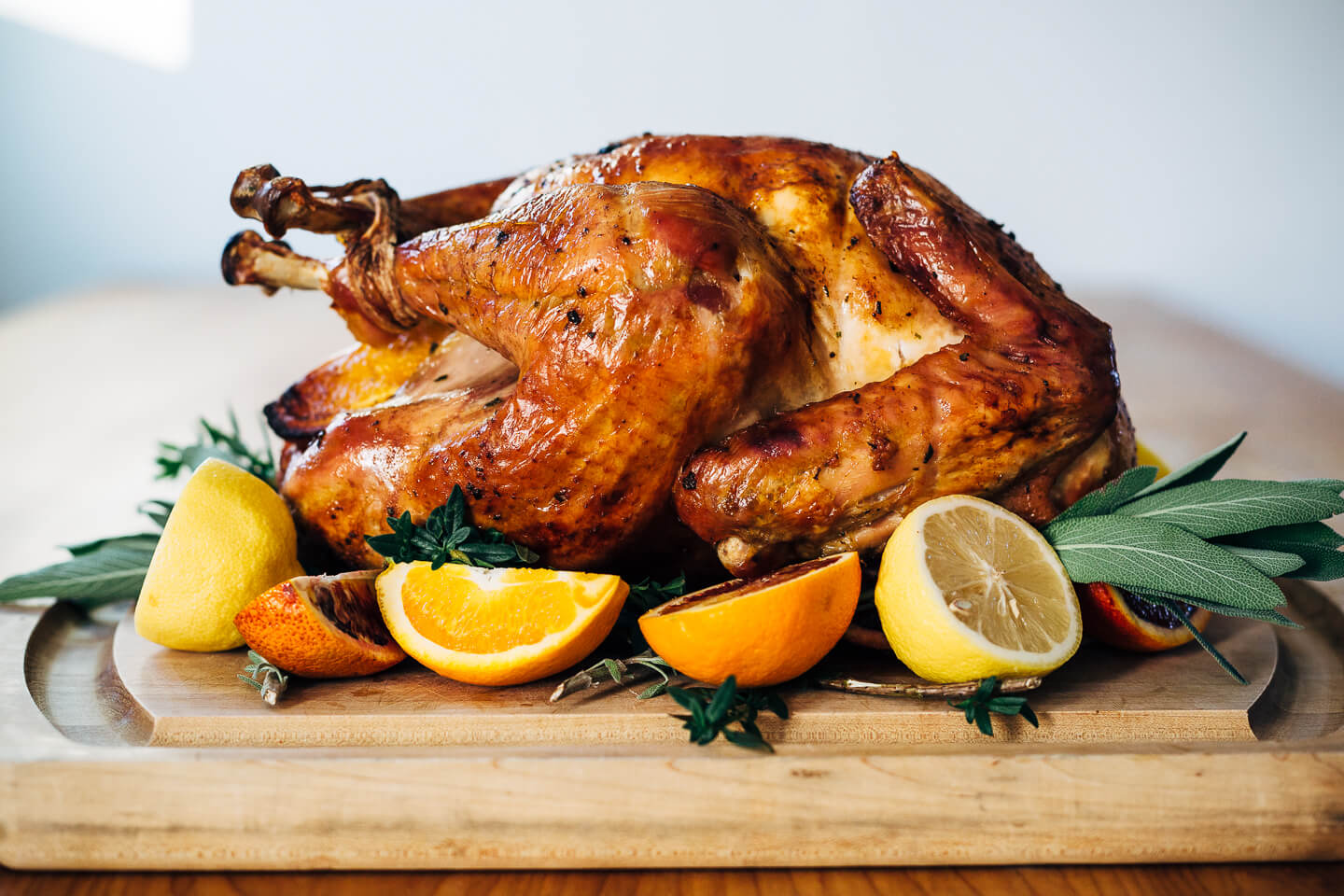 Citrus and herb roasted turkey, ready to be carved. Garnish with fresh citrus and herbs for presentation. 
