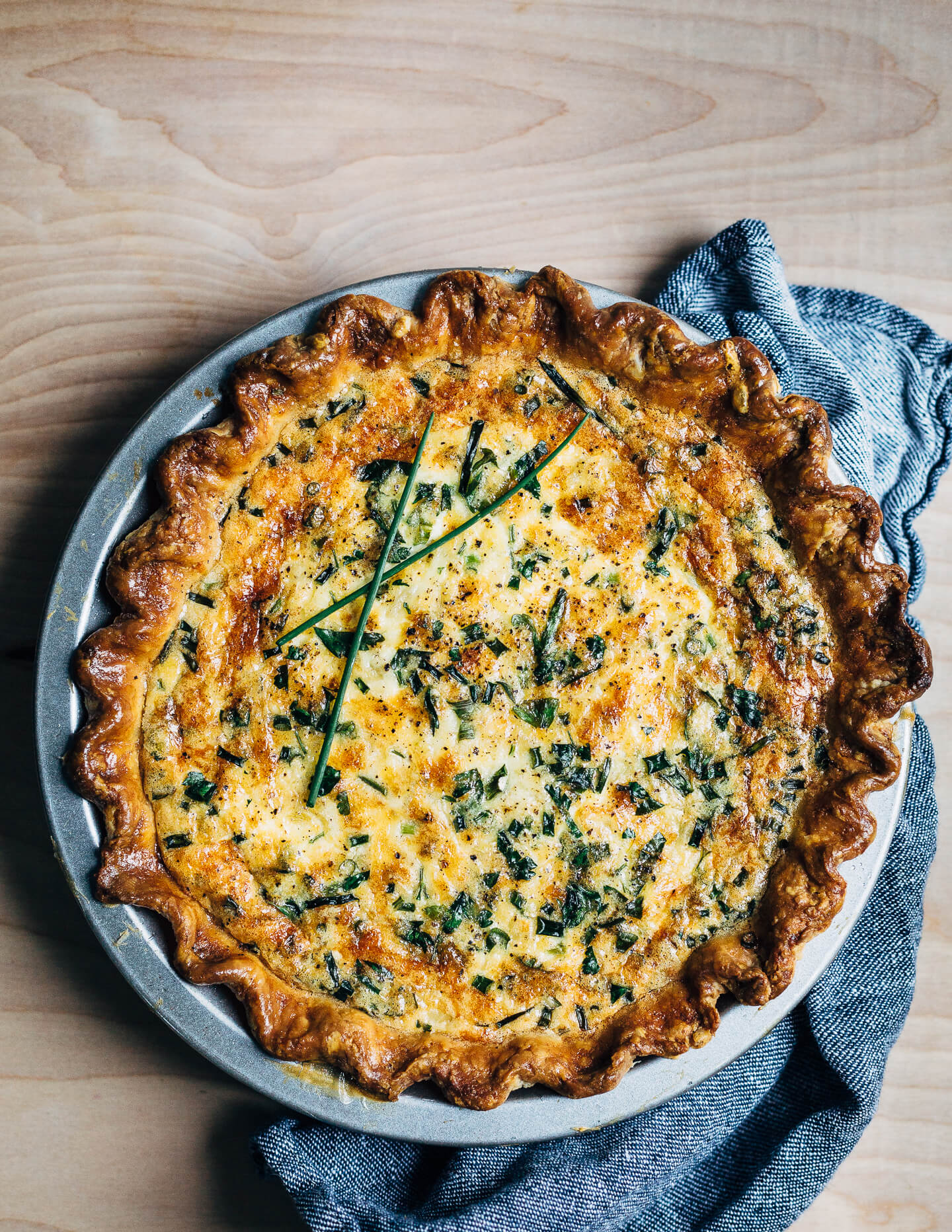 A simple chive and cheddar quiche recipe that makes the most out of refrigerator staples like eggs, cheddar, and butter. Yellow onions caramelized in butter and whatever fresh herbs you can find lend flavor and contrast to this wonderfully rich vegetarian quiche.