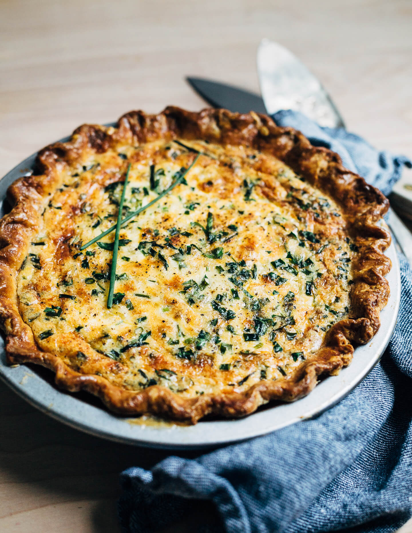 A simple chive and cheddar quiche recipe that makes the most out of refrigerator staples like eggs, cheddar, and butter. Yellow onions caramelized in butter and whatever fresh herbs you can find lend flavor and contrast to this wonderfully rich vegetarian quiche.