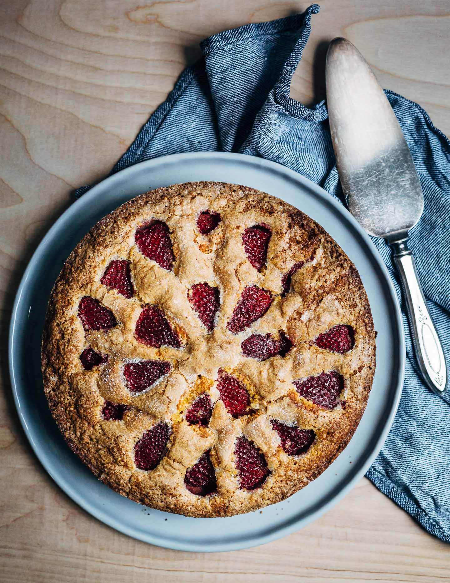 A rustic strawberry cornmeal cake with fresh strawberries, cornmeal, and flecks of polenta. 