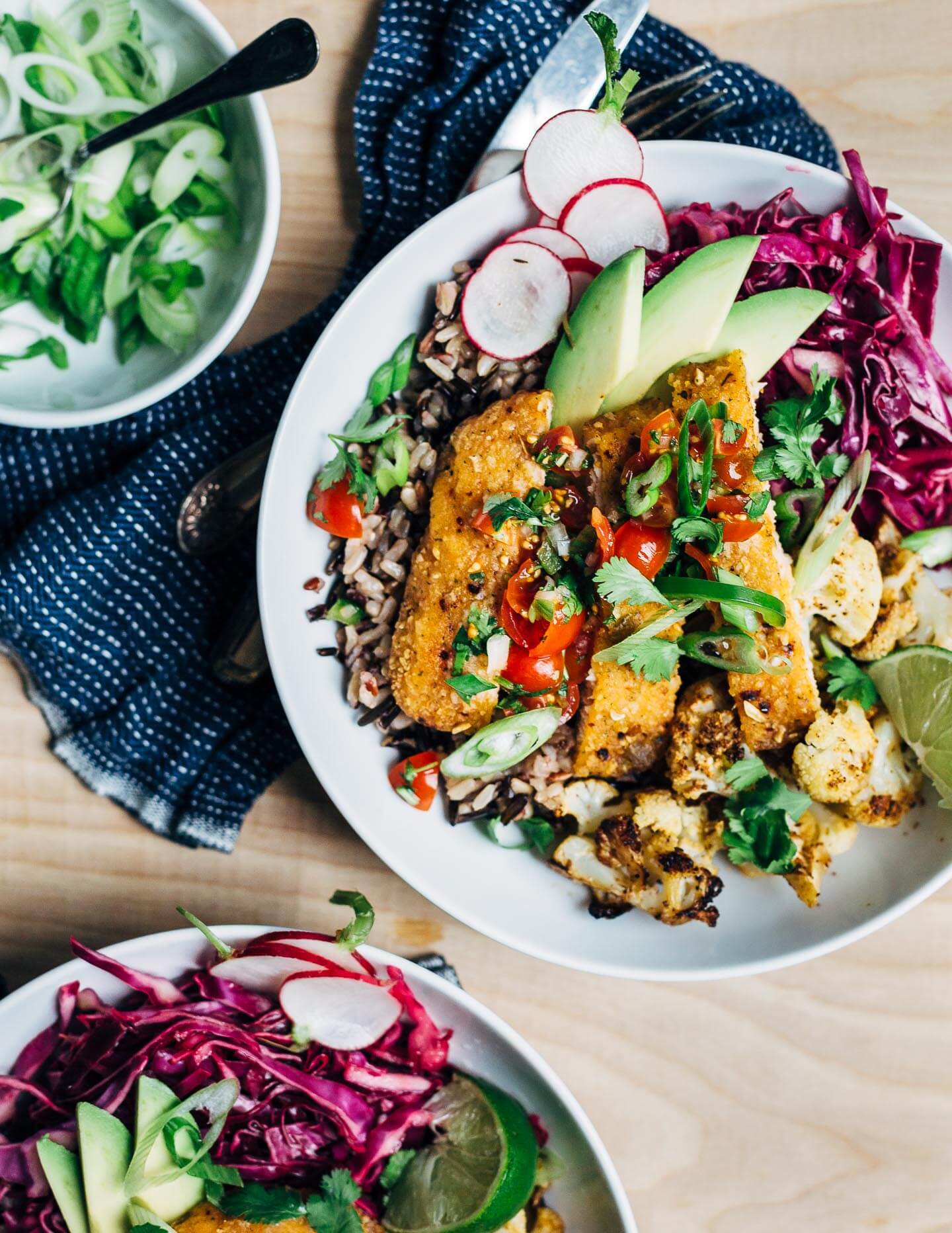 Vibrant honey-chipotle salmon taco bowls with wild rice, roasted cauliflower, cilantro, and a fresh cherry tomato and jalapeño relish. These simple salmon taco bowls are perfect for a quick and easy weeknight meal.