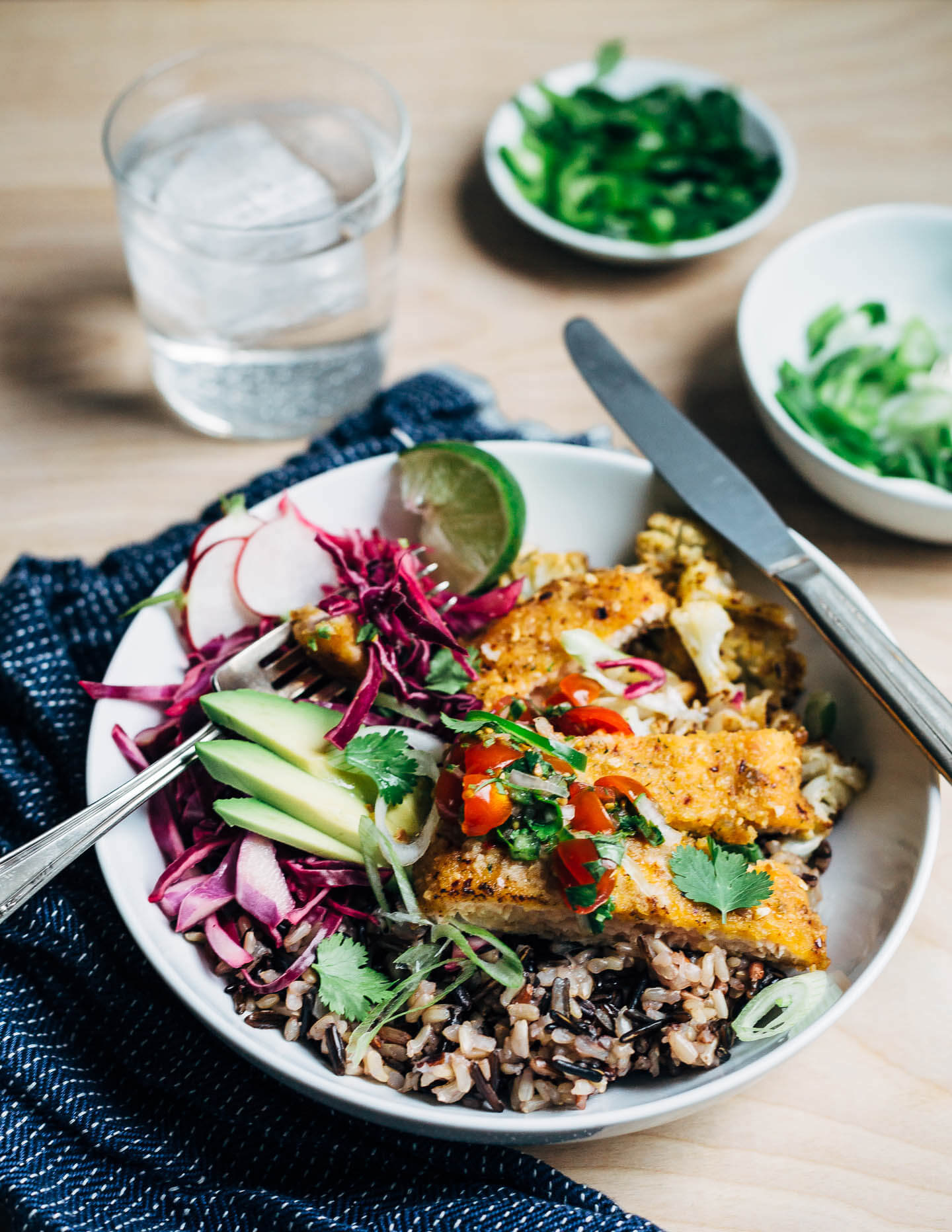 Vibrant honey-chipotle salmon taco bowls with wild rice, roasted cauliflower, cilantro, and a fresh cherry tomato and jalapeño relish. These simple salmon taco bowls are perfect for a quick and easy weeknight meal.