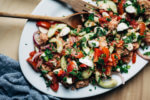 A classic summer salad, this panzanella with mozzarella and herbs features perfectly ripe summer tomatoes, a punchy garlic and anchovy vinaigrette.