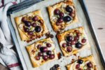 Sweet and savory brie and roasted grape tarts with a drizzle of honey, fresh thyme, and black pepper are the perfect simple-yet-decadent holiday appetizer.