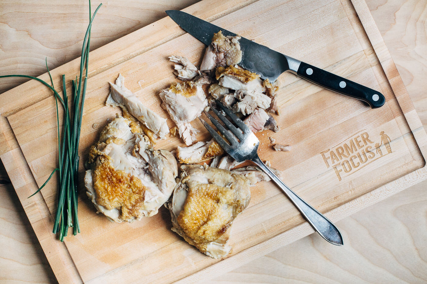 Pulling the cooked chicken from the bone. 