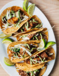 Nearly effortless and incredibly flavorful, these 20-minute baked fish tacos are layered with a simple charred green onion and avocado blender sauce and shredded green cabbage.