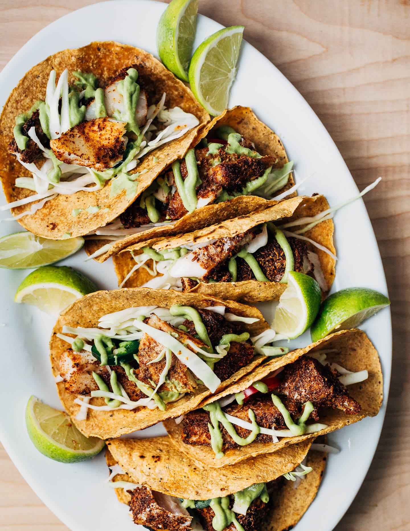 Nearly effortless and incredibly flavorful, these 20-minute baked fish tacos are layered with a simple charred green onion and avocado blender sauce and shredded green cabbage.