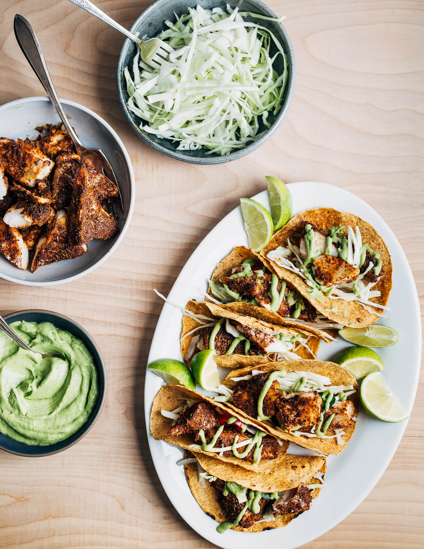 Nearly effortless and incredibly flavorful, these 20-minute baked fish tacos are layered with a simple charred green onion and avocado blender sauce and shredded green cabbage.