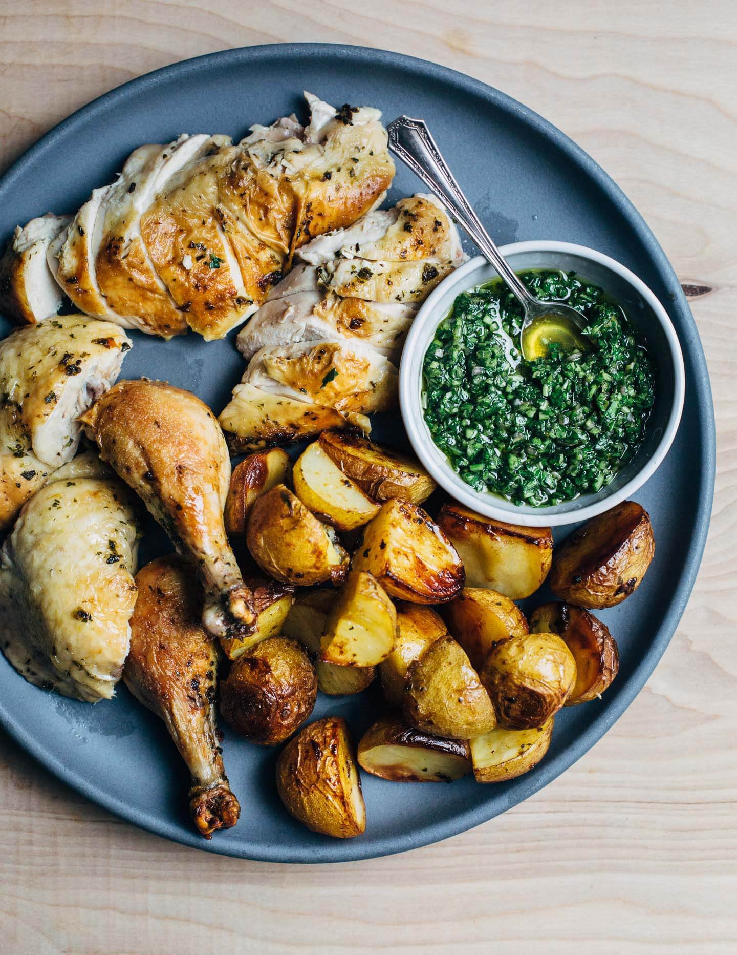 Chimichurri roasted chicken and potatoes, arranged on a platter and ready to serve.