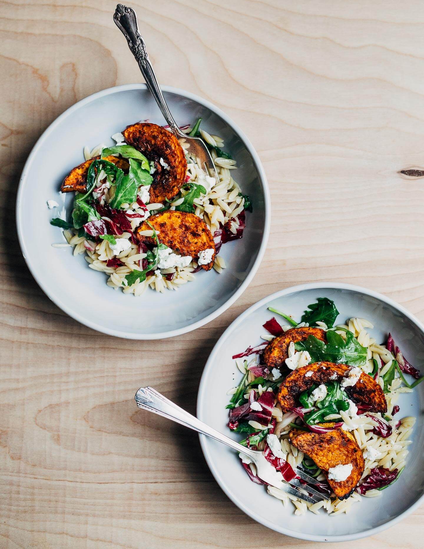 Roasted butternut squash and orzo salad with sturdy greens and goat cheese.