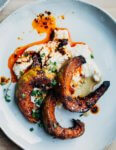 A plate with roasted squash, chili oil, and a dollop of ricotta.