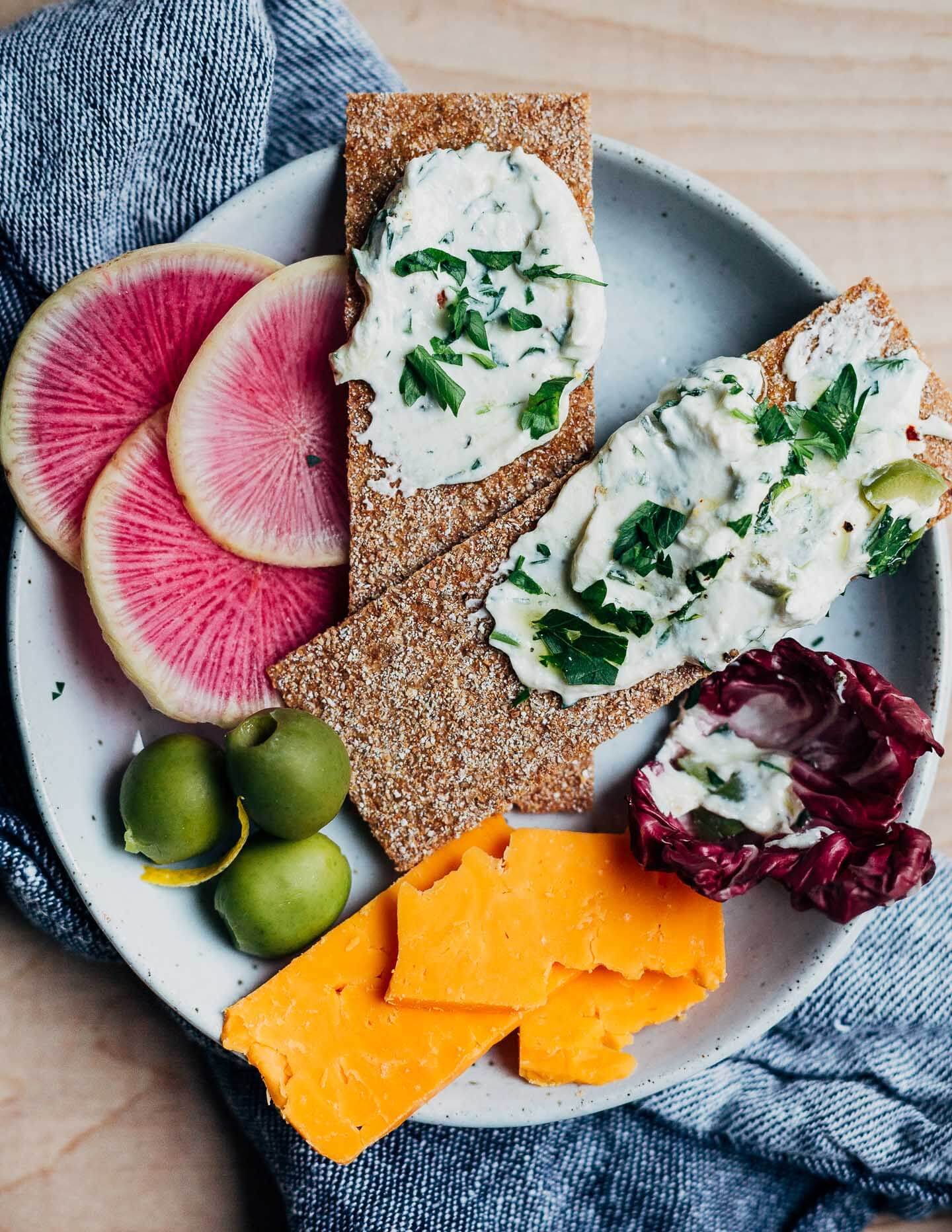 Plated holiday snack board with whipped goat cheese dip.