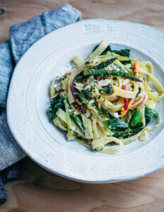 A bowl of fettuccine swirled with spring vegetables.