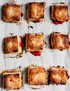 A baking sheet with nine square strawberry basil hand pies.