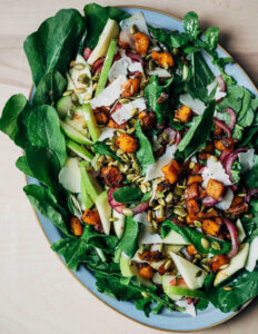A platter of salad with roasted squash and apples.