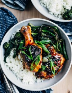A wide bowl with chicken, rice, and broccoli rabe.