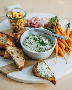 Pimento cheese, toast and carrots on a serving board.