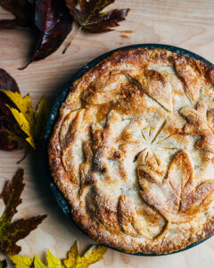 Looking down on a whole pie with a decorative leaf crust.